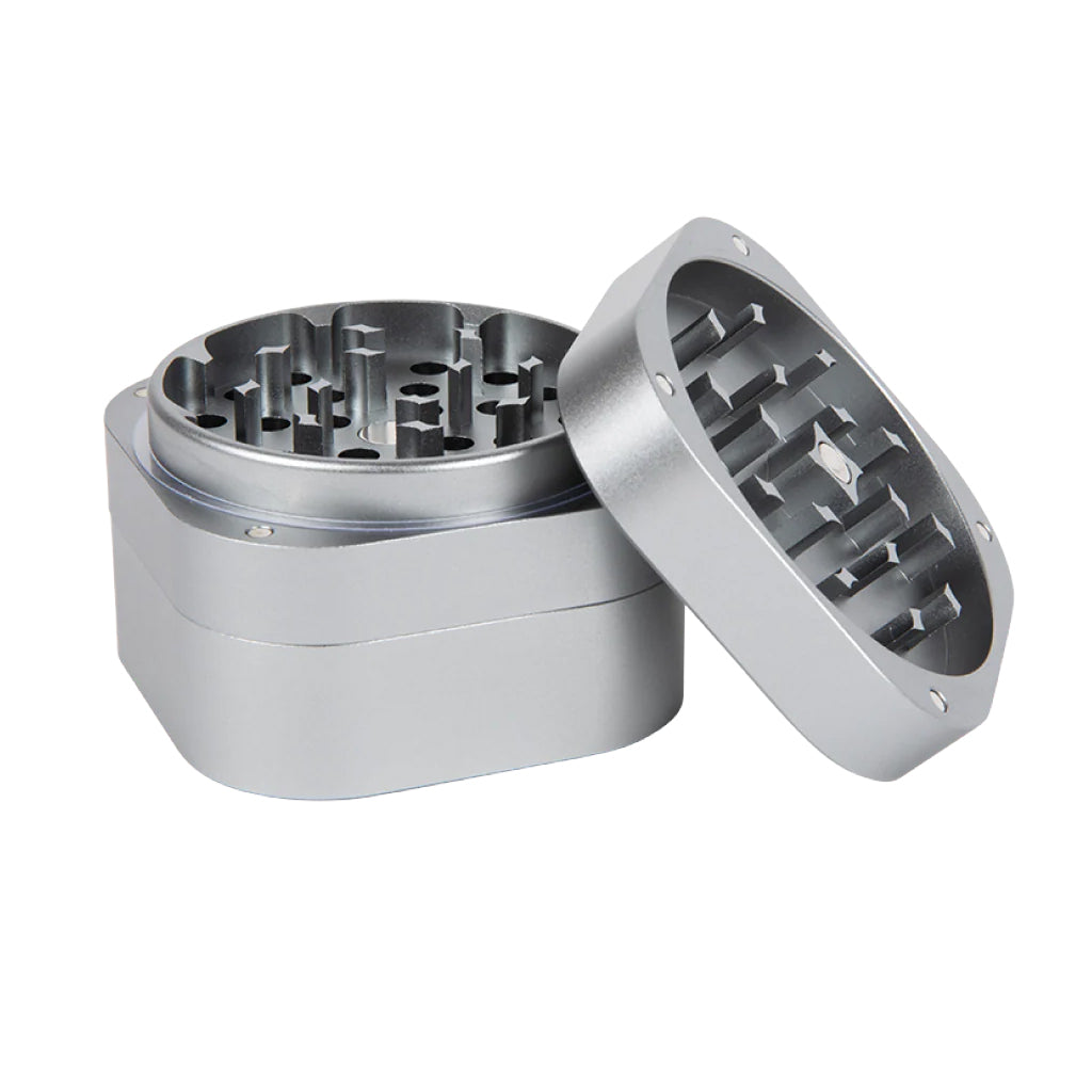 Angled view of the open 3 Piece Heavy-Duty Aluminum Grinder in silver, revealing its sharp grinding teeth and magnetic closure system.